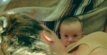 a woman holding a baby under a blanket