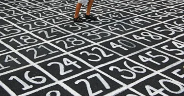 person in white shirt and blue denim shorts standing on black and white floor